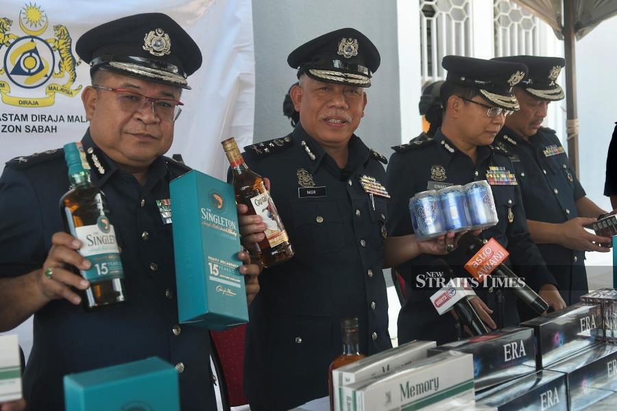 Deputy Sabah Customs director Datuk Mohd Nasir Deraman (second from left) showing some of the seized contraband items. NSTP Pic