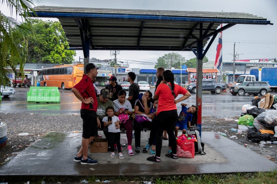 Venezuelan migrants take shelter from the rain at a bus stop on the Costa Rica- Panama border as they attempt to return after failing to cross into the United States due to US President Donald Trump's new immigration policies, in Paso Canoas, Costa Rica. (REUTERS/Maynor Valenzuela)