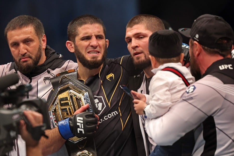 Islam Makhachev (2nd-L) celebrates with his team after defeating Charles Oliveira in the lightweight championship at the Ultimate Fighting Championship (UFC) event at the Etihad Arena in Abu Dhabi. - AFP pic