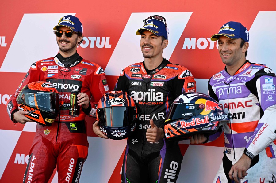Aprilia Spanish rider Maverick Vinales (centre), celebrates getting the pole position as he poses with second placed Ducati Italian rider Francesco Bagnaia (left) and third, Ducati French rider Johann Zarco, after the qualifying session of the MotoGP Valencia Grand Prix at the Ricardo Tormo racetrack in Cheste. - AFP pic