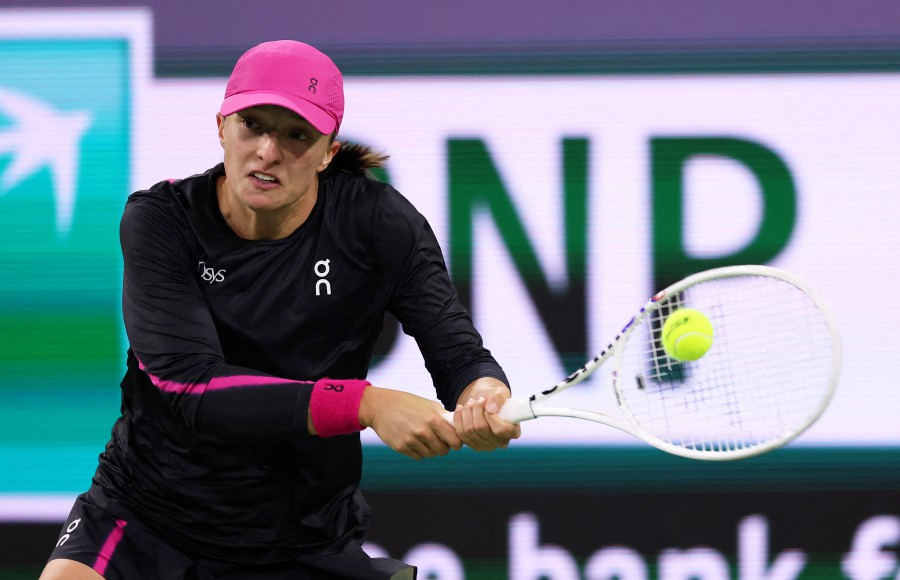 INDIAN WELLS, CALIFORNIA - MARCH 12: Iga Swiatek of Poland plays a backhan against Yulia Putintseva of Kazakhstan in their fourth round match during the BNP Paribas Open at Indian Wells Tennis Garden on March 12, 2024 in Indian Wells, California. Clive Brunskill/Getty Images/AFP (Photo by CLIVE BRUNSKILL / GETTY IMAGES NORTH AMERICA / Getty Images via AFP)