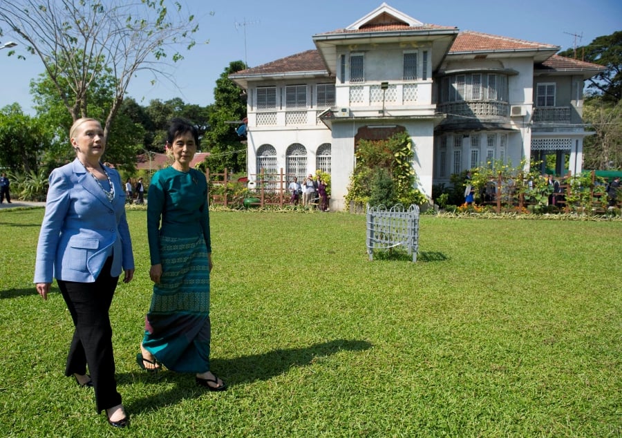 U.S. Secretary of State Hillary Clinton (L) and Myanmar's pro-democracy leader Aung San Suu Kyi tour the grounds after their meeting at Suu Kyi's house in Yangon December 2, 2011. REUTERS File Photo/Saul Loeb