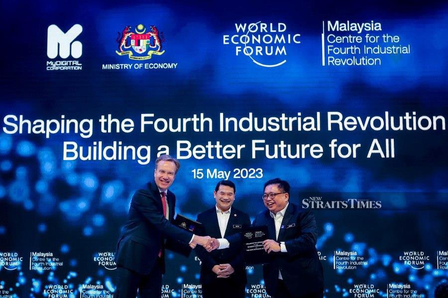 Economy Minister, Rafizi Ramli (center) witnessing World Economic Forum president, Børge Brende (left) exchanging document with MyDigital chief executive officer, Fabian Bigar (right) during the Malaysia Centre for the Fourth Industrial Revolution launch at Kuala Lumpur Convention Center (KLCC). - NSTP/ASYRAF HAMZAH