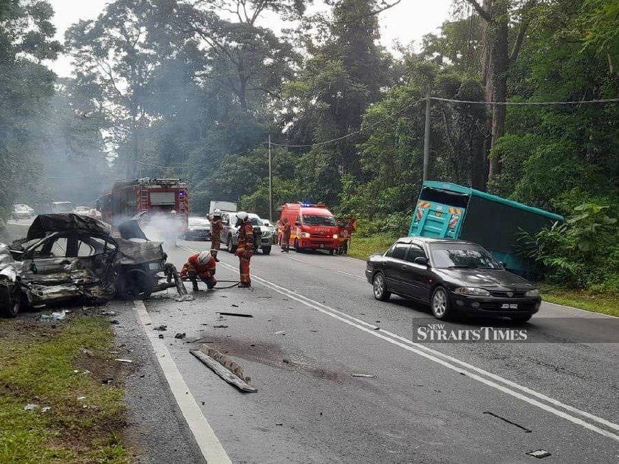 Firemen at the scene following the crash on Bukit Mantin Road. - Pic courtesy of the Fire and Rescue Department 