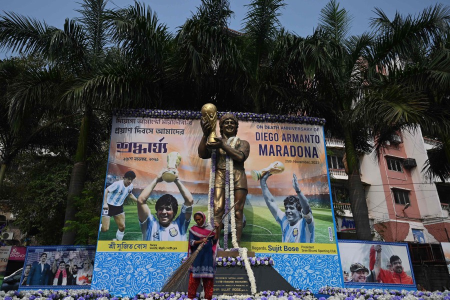 A municipal worker cleans a stage set up in front of a statue of late Argentine soccer legend Diego Armando Maradona to observe his first death anniversary in Kolkata. - AFP PIC