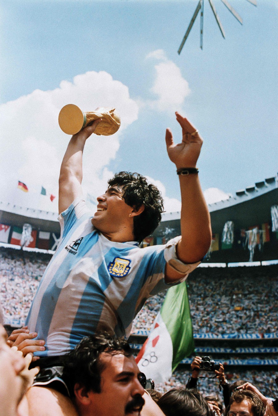 Argentina's football star team captain Diego Maradona brandishes the World Soccer Cup won by his team after a 3-2 victory over West Germany at the Azteca stadium in Mexico City. - AFP PIC