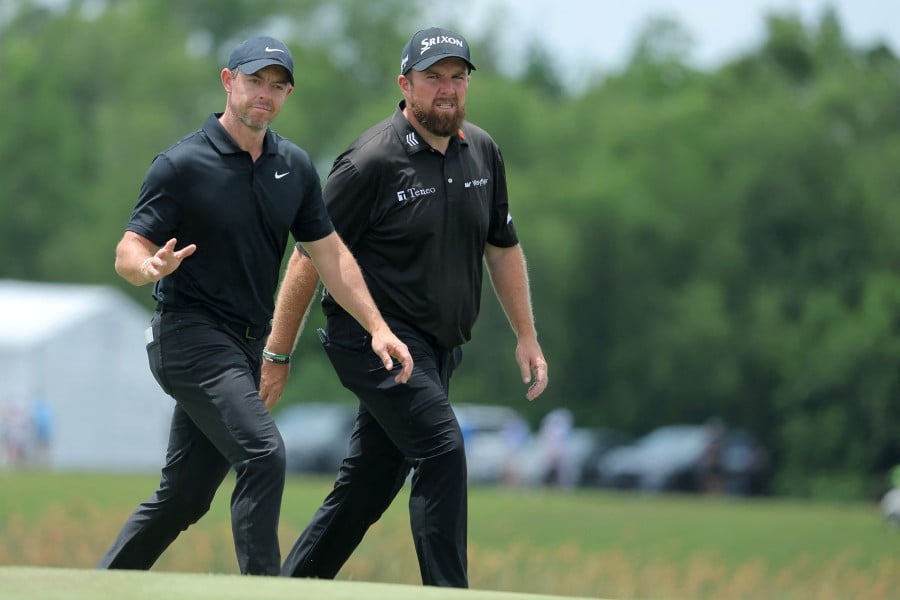(L-R) Rory McIlroy of Northern Ireland and Shane Lowry of Ireland wave on the ninth green during the second round of the Zurich Classic of New Orleans at TPC Louisiana in Avondale, Louisiana.-AFP PIC