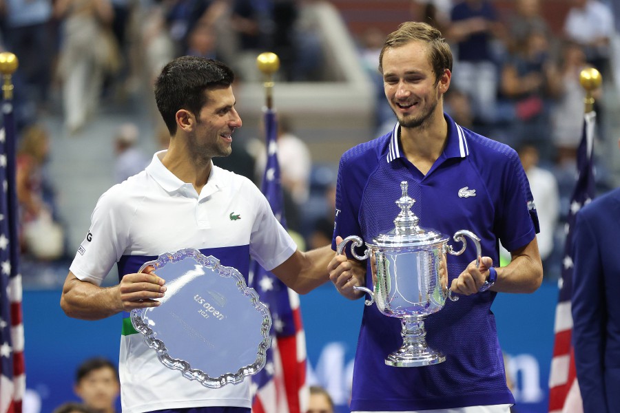 (L-R) Novak Djokovic of Serbia holds the runner-up trophy alongside Daniil Medvedev of Russia who celebrates with the championship trophy after winning their Men's Singles final match on Day Fourteen of the 2021 US Open at the USTA Billie Jean King National Tennis Center in the Flushing neighbourhood of the Queens borough of New York City. - AFP PIC
