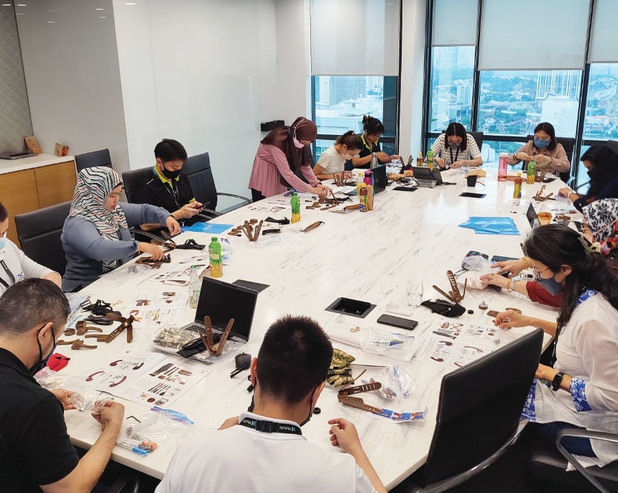 MetLife Malaysian employees assembling prosthetic hands to help amputees from low-income backgrounds with life-changing impacts during the ‘Build-a-Hand’ workshop.