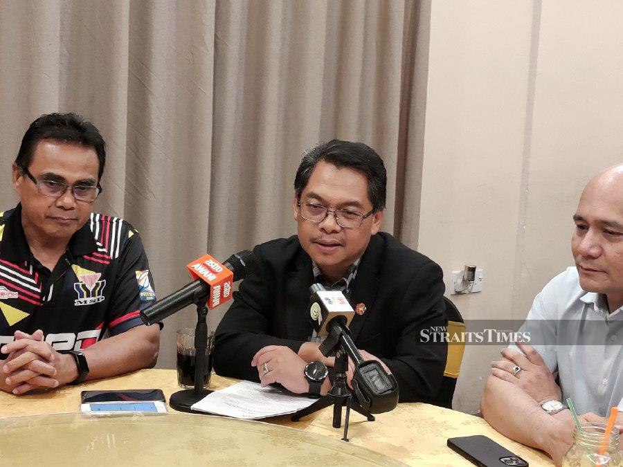Datuk Mustapha Sakmud (centre) speaking during a press conference in Kota Kinabalu. -NSTP/IZWAN ABDULLAH