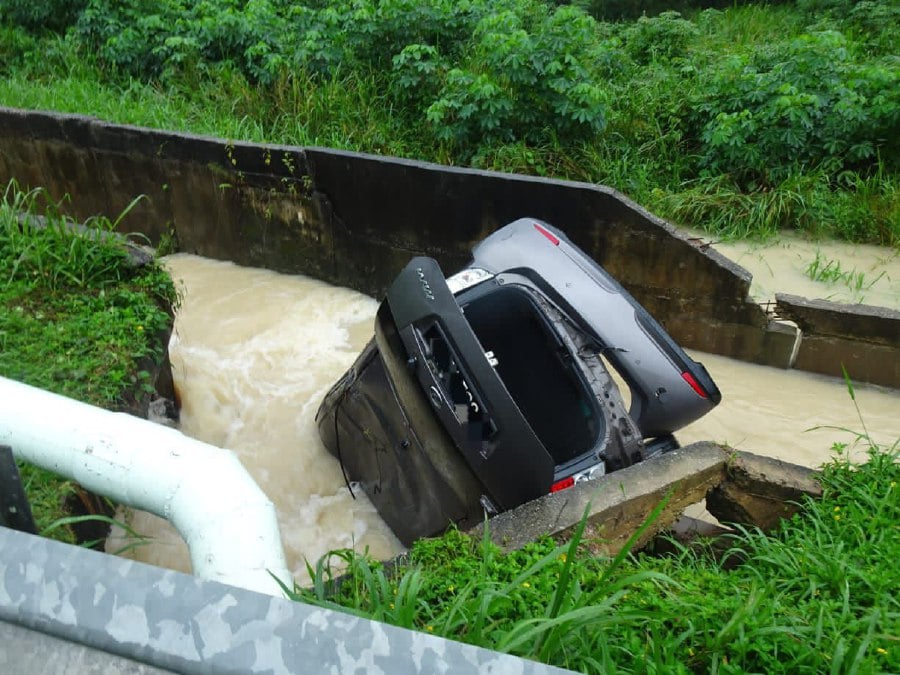 Two women were rescued by a man who jumped into a drain overflowing with gushing floodwaters after their car skidded into it, along KM 42.5 of the Johor Baru - Mersing Highway, here today. Pic courtesy of PDRM