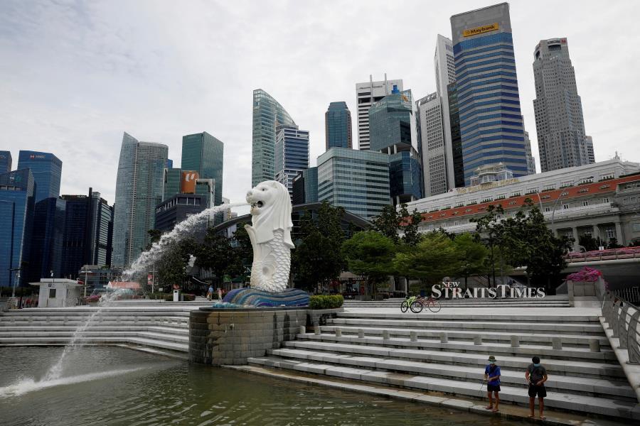 FILE PHOTO: Youth fish at a largely empty Merlion Park in Singapore.  REUTERS/Edgar Su/File Photo