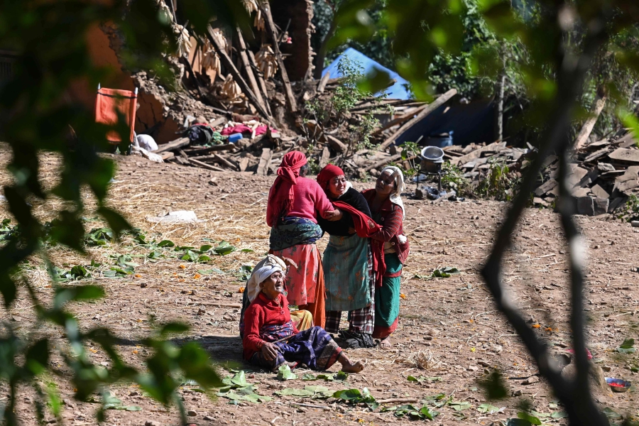 Family members of earthquake victims, mourn after their bodies were take to a mass cremation ceremony in Chiuri village at Jajarkot district. (Photo by Prakash MATHEMA / AFP)