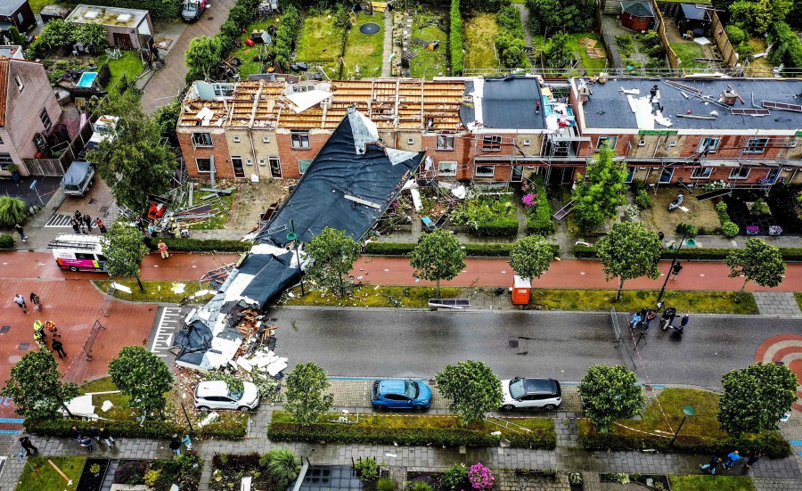 An aerial view shows the damage to the roof of adjacent buildings after a tornado ripped through the southwestern seaside city of Zierikzee on June 27, 2022. - A tornado ripped through the city of Zierikzee, killing at least one person and injuring 10 others in the first fatal twister to hit the country for three decades. (Photo by Jeffrey GROENEWEG / ANP / AFP)