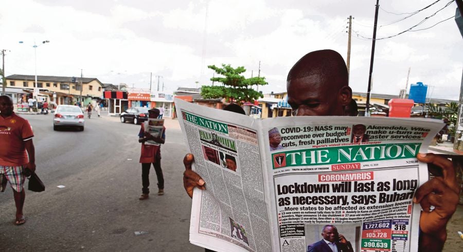 A man reads a newspaper at a newsstand in Lagos. AFP