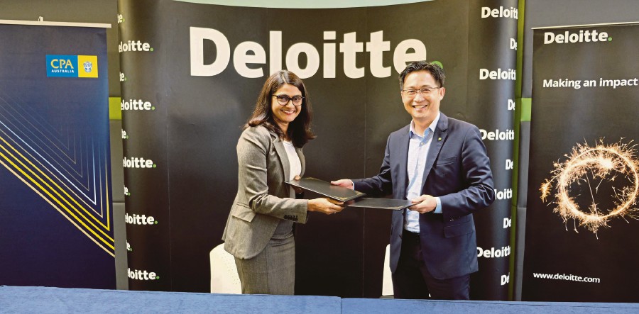 Deloitte Malaysia Audit and Assurance leader Stanley Teo exchanging the document after the signing ceremony with CPA Australia country head for Malaysia Priya Terumalay.