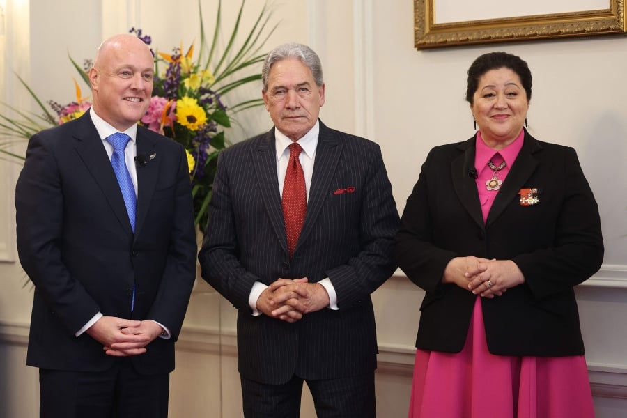 (L-R) New Zealand's new Prime Minister Christopher Luxon, New Zealand's Deputy Prime Minister Winston Peters, and New Zealand's Governor General Dame Cindy Kiro attend the swearing-in of the new government at Government House in Wellington. (Photo by Marty MELVILLE / AFP)