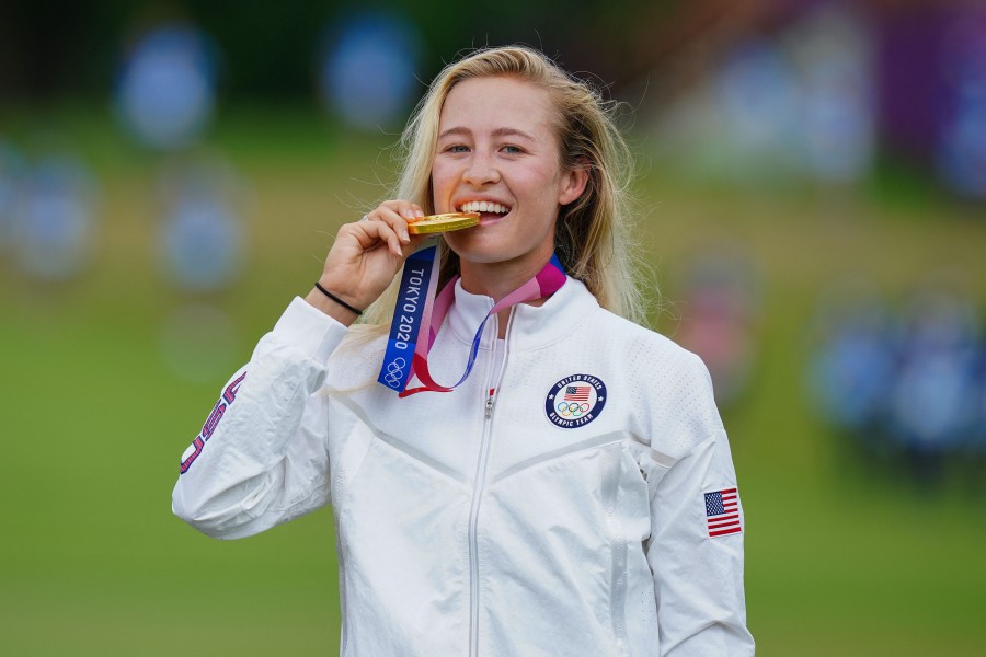 Gold medallist USA's Nelly Korda bites her medal on the podium during the victory ceremony of the women�s golf individual stroke play during the Tokyo 2020 Olympic Games at the Kasumigaseki Country Club in Kawagoe on August 7, 2021. (Photo by YOSHI IWAMOTO / AFP)