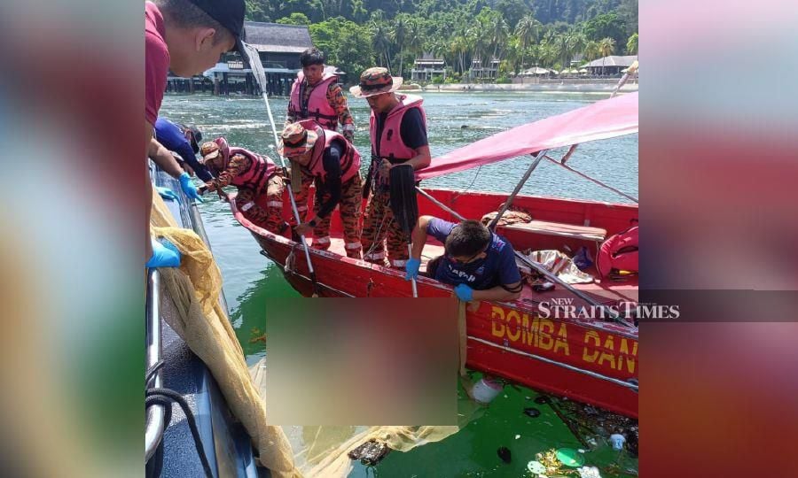 Firemen extricate the remains of an individual found floating in the waters of Pulau Pangkor. - Pic courtesy of police