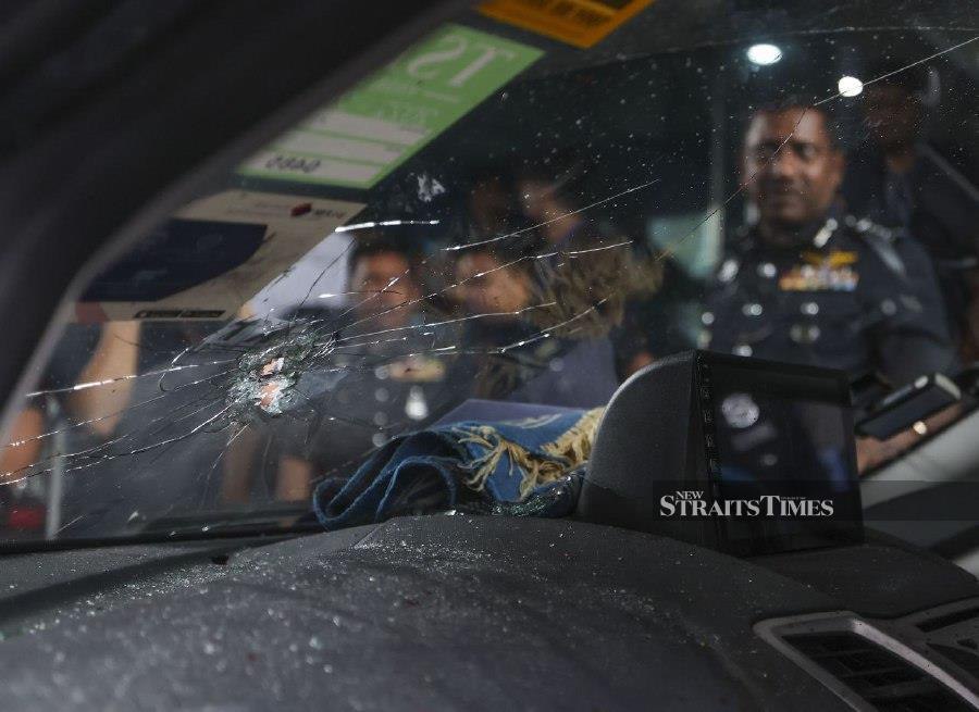 KUALA LUMPUR: Selangor police chief Datuk Hussein Omar Khan (right) looking at the bullet holes on a Ford Fiesta that was used by three suspects who was gunned down by police early this morning. - BERNAMA PIC