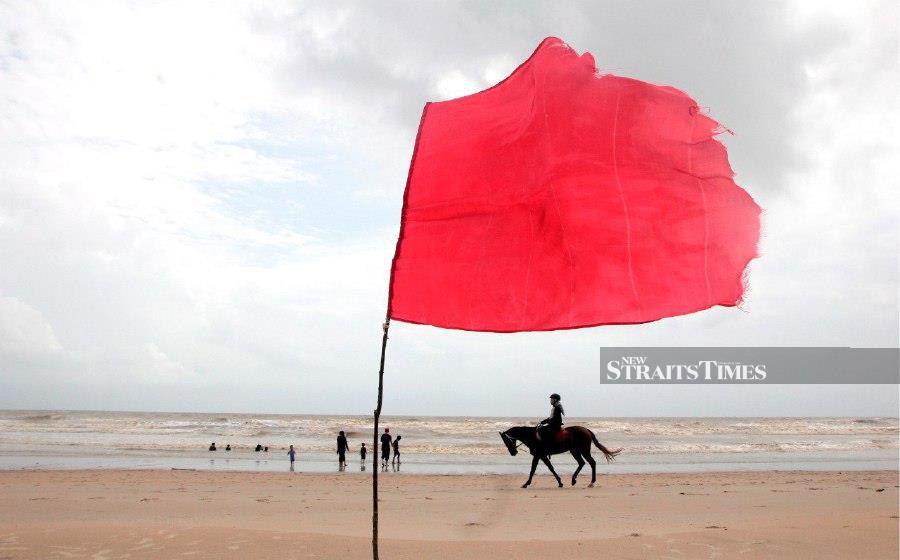 KUANTAN: A red flag being hoisted to warn visitors against engaging in water activities at the Sepat Beach following report of rough seas and strong waves. -- BERNAMA PIC