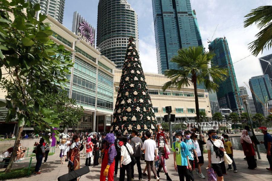 KUALA LUMPUR: City folks flocking to the Suria KLCC while taking the opportunity to take pictures with a giant Christmas tree with the Petronas Twin Towers in the background.- BERNAMA PIC
