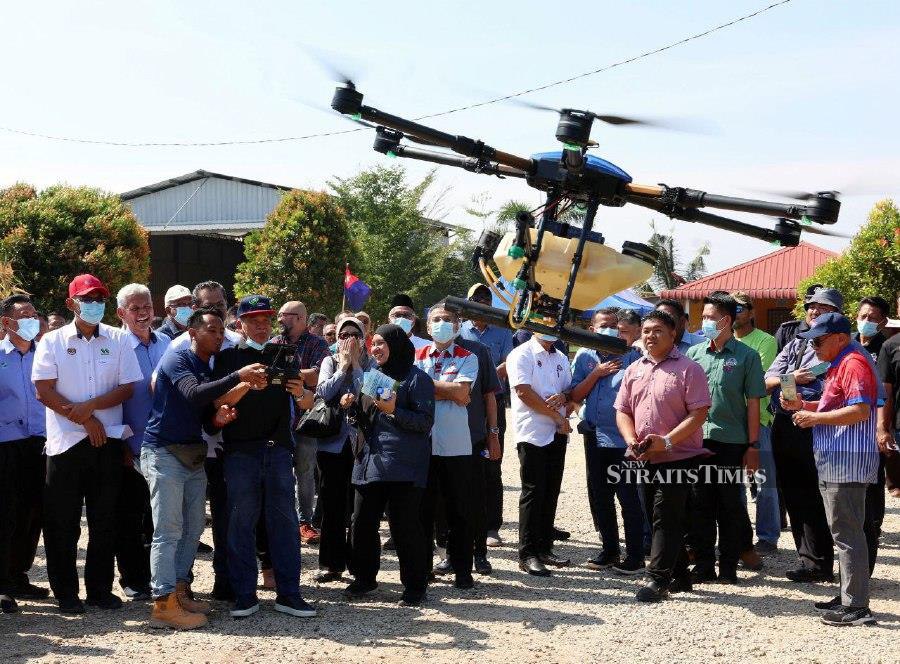 TANGKAK - Agriculture and Food Security Minister Datuk Seri Mohamad Sabu tryies to launch a drone used for spraying pesticides at a paddy field during a visit to the Rice Planting Project in Kampung Sawah Ring, Tangkak, Johor. --BERNAMA PIC