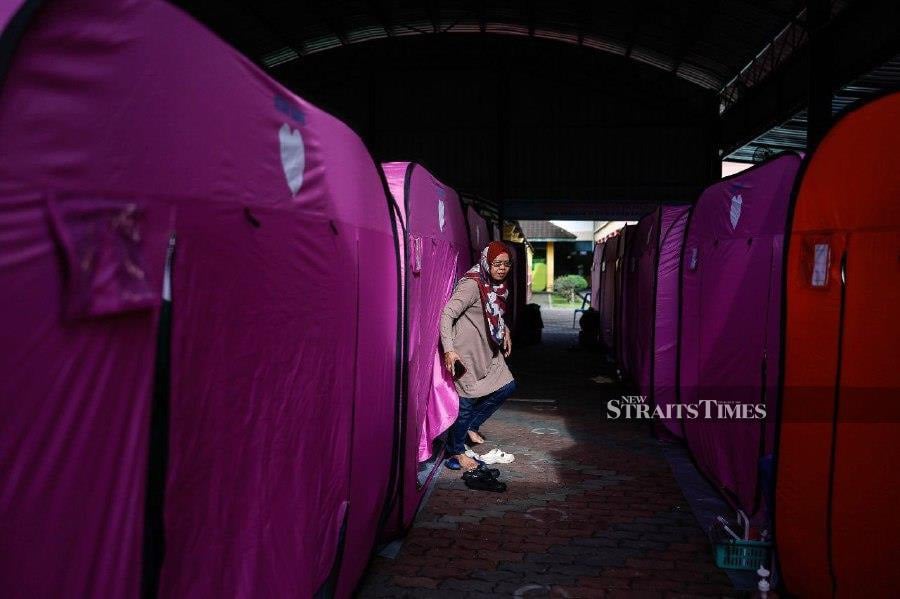 KOTA TINGGI: A flood victim emerges from a tent at a Temporary Flood Relief Center (PPS) in Taman Kota Jaya, Kota Tinggi on Tuesday (January 9). -- BERNAMA PIC