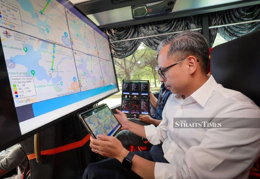KUALA LUMPUR: Communications Minister Fahmi Fadzil observes the mobile call quality monitoring screen during the implementation of the Cellular Service Quality Test (Voice Calls). -- BERNAMA PIC