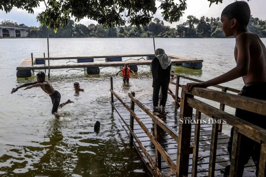 KUALA TERENGGANU: A group of teenagers taking a dip in the Kampung Pulau Manis Serada River, seeking relief from the intense heat, expected to persist until July. -- NSTP/GHAZALI KORI