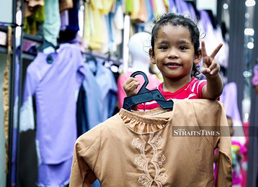 KUALA LUMPUR: Recipient of aid from the Ikram Malaysia Foundation, Allysha, with the baju kurung she chose for the upcoming Hari Raya Aidilfitri celebration. - NSTP/RAIHANA MANSOR