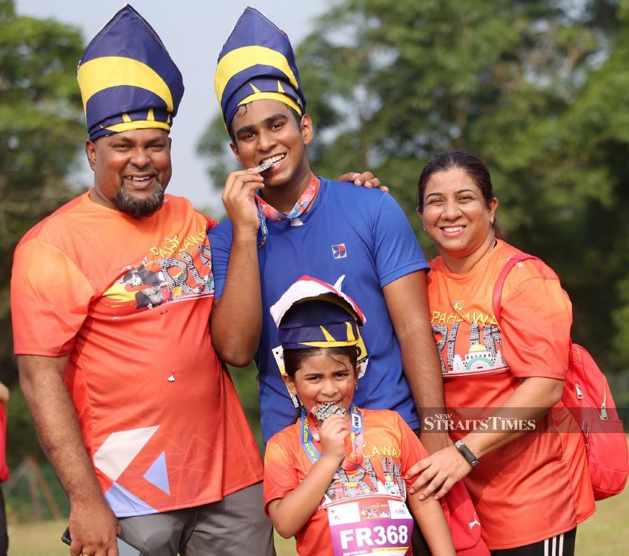 Thevendran (left), his wife, L Anushia, 43, and children T Harsyikha, 6, and T Sailesh, 15, were among 870 participants in the 'Run With Your Tanjak' Pahlawan Run 2019 programme at Kolej Yayasan Saad, Durian Tunggal, here today. NSTP/RASUL AZLI SAMAD