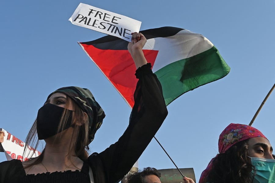 Protesters carry placards and wave flags of Palestine as they take part in a demonstration in support of Palestine during an anti-Israel protest rally in Islamabad on May 17, 2021. (Photo by Aamir QURESHI / AFP)