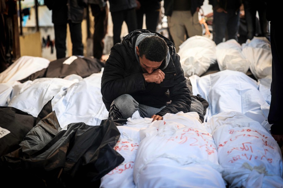A Palestinian man mourns over shrouded bodies of relatives killed in overnight Israeli bombardment on the southern Gaza Strip at Al-Najjar hospital in Rafah on February 8, 2024, as the conflict between Israel and Hamas enters its fifth month. AFP PIC