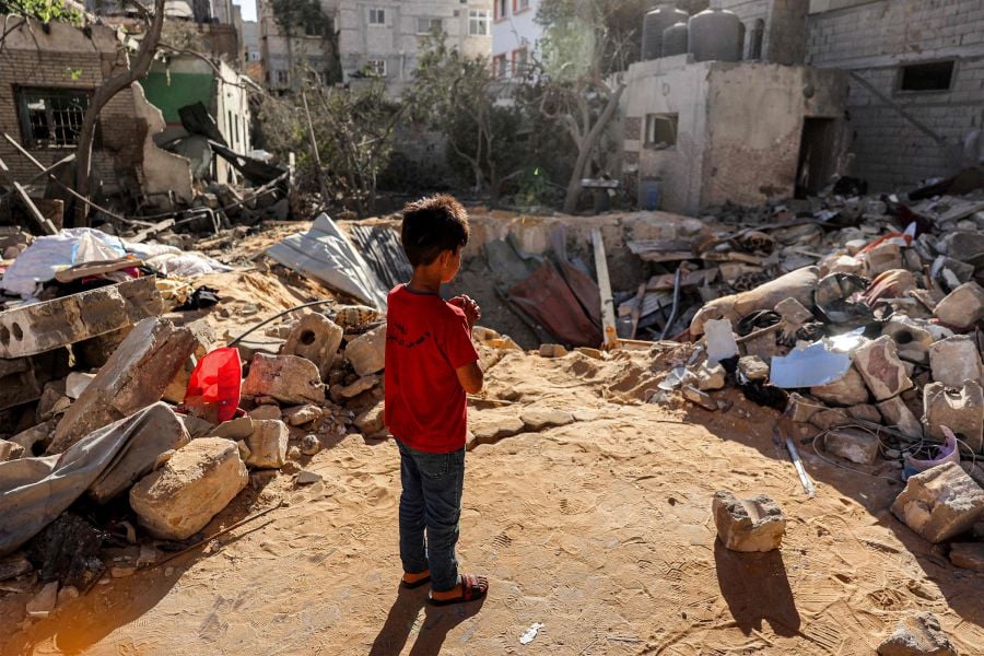 A boy stands before an impact crater at the site of a building that was hit by Israeli bombardment in Rafah in the southern Gaza Strip on May 8, 2024. - AFP pic