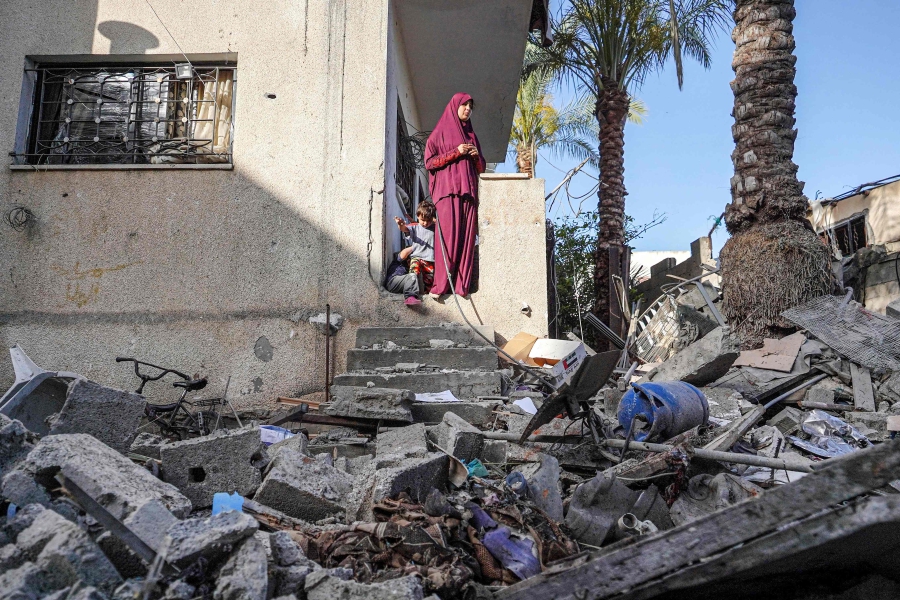 A Palestinian woman checks the damages at her family house in Nuseirat following Israeli bombardment overnight. (Photo by Bashar TALEB / AFP)