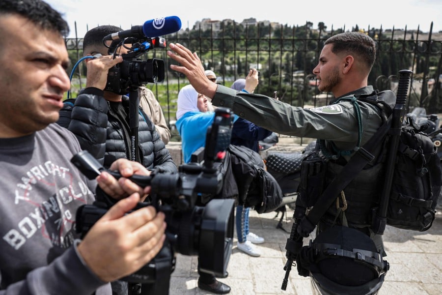 A member of Israel's security forces stands in front of members of the press near Lion's Gate in Jerusalem, as Muslim worshippers wait to enter the Al-Aqsa Mosque compound for the Friday noon prayer, on March 1, 2024. AFP PIC
