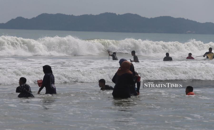 The arrival of the northeasterly with a wind speed of up to 50kph and high waves is usually not a good time for anyone to look for clams in waist-deep water near the beach. - NSTP/IMRAN MAKHZAN