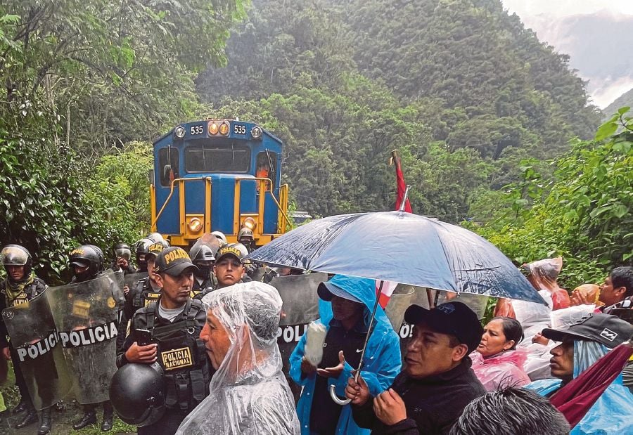 Tour operators and residents demonstrate against the opening of online ticket sales to the Inca citadel as policemen secure the rail tracks near Machu Picchu Pueblo. (Photo by Carolina Paucar / AFP)