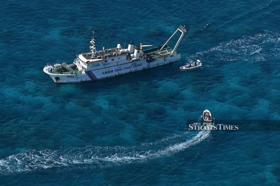 This photo taken on February 15, 2024, shows an aerial view of an China Coast Guard vessel (upper) and China Coast Guard personnel on a rubber boat at Scarborough Shoal in the disputed South China Sea. AFP FILE PIC