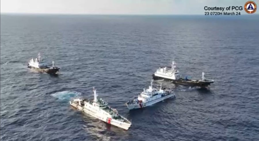 A China Coast Guard ship (2nd L) and vessels identified by the Philippine Coast Guard as ‘Chinese Maritime Militia’ (L and R) surrounding the Philippine Coast Guard ship BRP Cabra (2nd R) during its supply mission near Second Thomas Shoal in waters of the disputed South China Sea. - AFP PIC