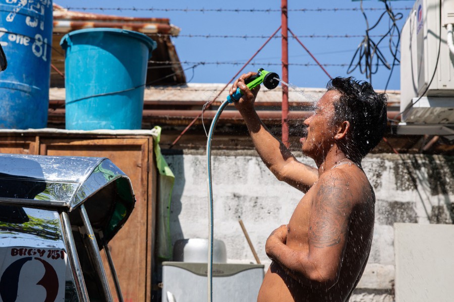 A man showers with a hose during hot weather in Manila on April 28, 2024. The Philippines will suspend in-person classes in all public schools for two days due to extreme heat and a nationwide strike by jeepney drivers, the education department said on April 28. AFP PIC