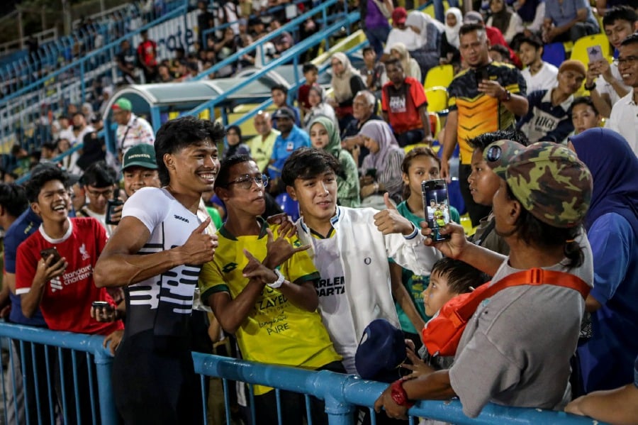  KUANTAN: National sprint champion Muhammad Azeem Fahmi obliges and poses for pictures with fans after winning the men's 100m final at the Malaysian Open Athletics Championship at the Darul Makmur Stadium. — NSTP/LUQMAN HAKIM ZUBIR 