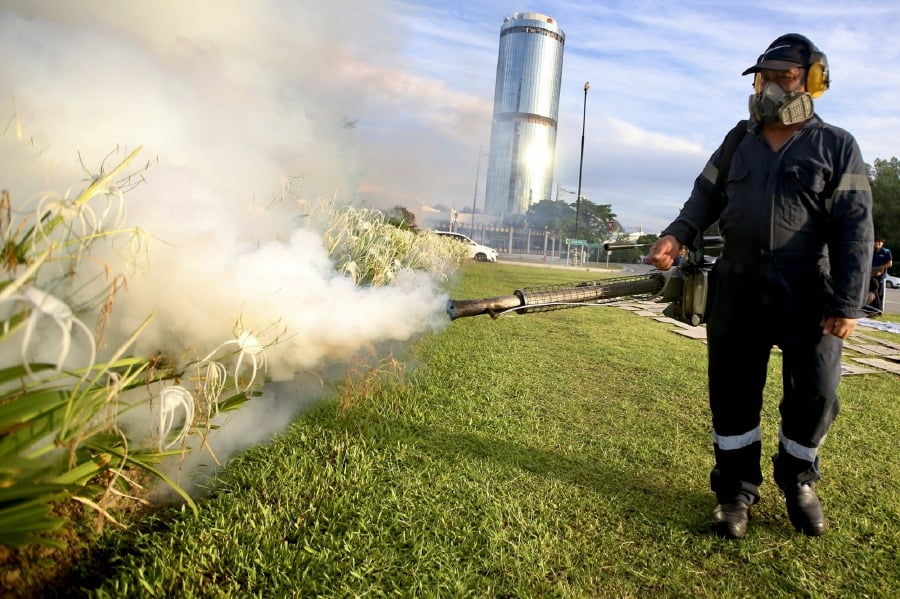 ` KOTA KINABALU: A contractor carries out fumigation to combat the spread of Dengue at the Kinabalu Tower grounds. — STR/MOHD ADAM ARININ