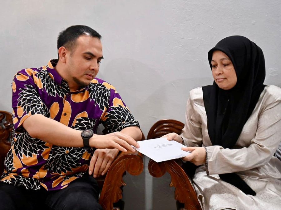  Prime Minister Datuk Seri Anwar Ibrahim’s political secretary Ahmad Farhan Fauzi (Left) hands over contribution to the widow of Md Rizal Atan who passed away in an incident involving an uprooted tree on Jalan Sultan Ismail last week. — COURTESY OF DATUK SERI ANWAR IBRAHIM’S FACEBOOK
