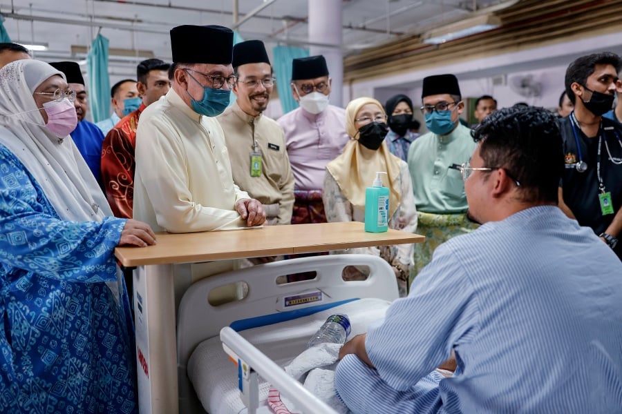 Datuk Seri Anwar and his wife, Datuk Seri Dr Wan Azizah Wan Ismail, visited some of the patients admitted in the third-class wards and hospital staff members before handing out some Hari Raya goodies to them. - Bernama pic
