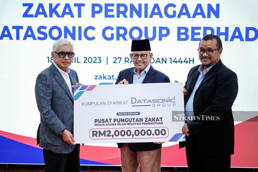 The company’s executive chairman, Datuk Hanifah Noordin (left), handed the zakat through a cheque to PPZ-MAIWP chairman Tan Sri Dr Abdul Aziz Abdul Rahman (center). -NSTP/HAZREEN MOHAMAD