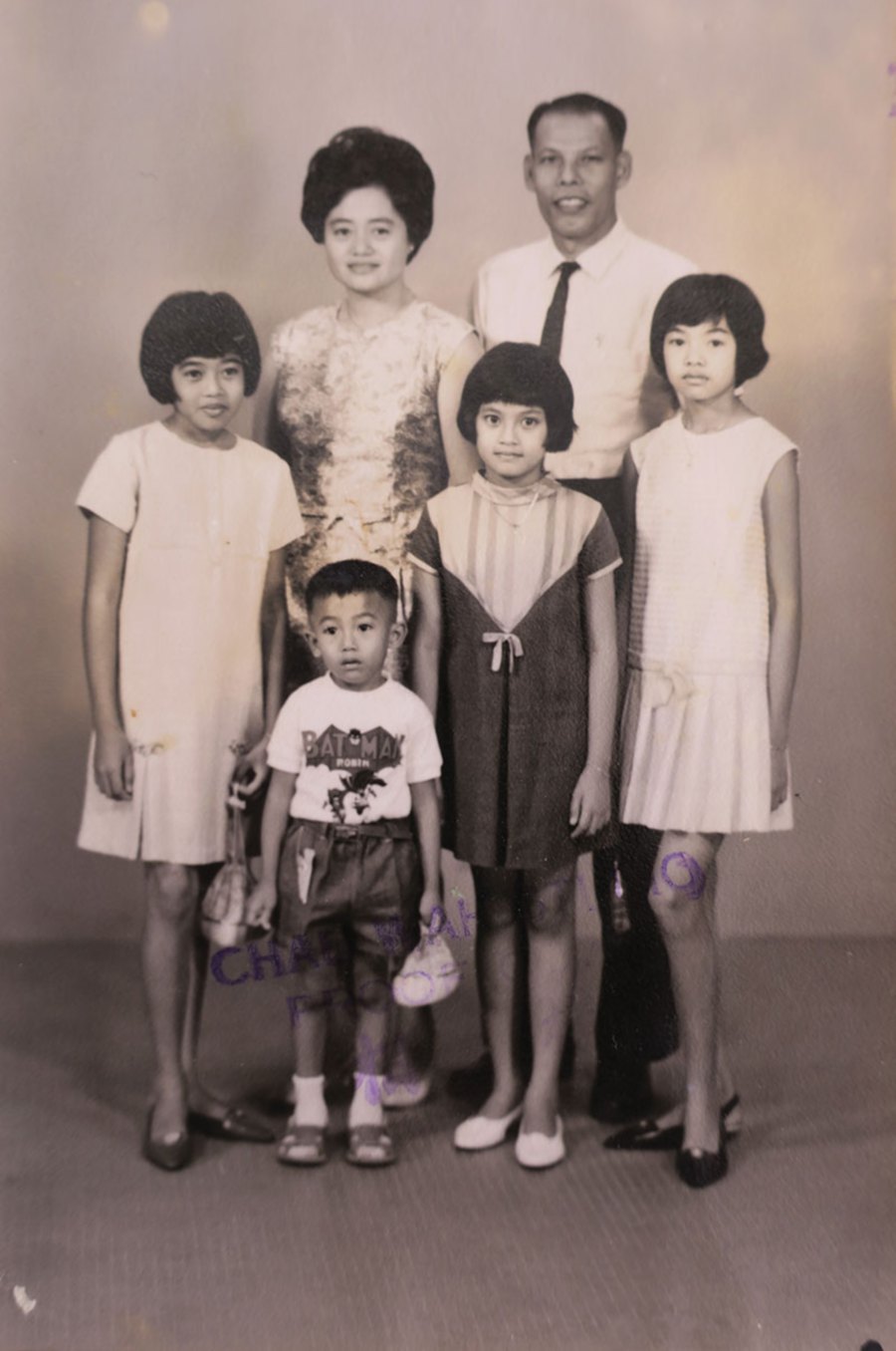 Formal photo of the Loh family taken in Chau Wah Photo Studio; This is the proof copy – notice the stamp across the photo – provided for review. 