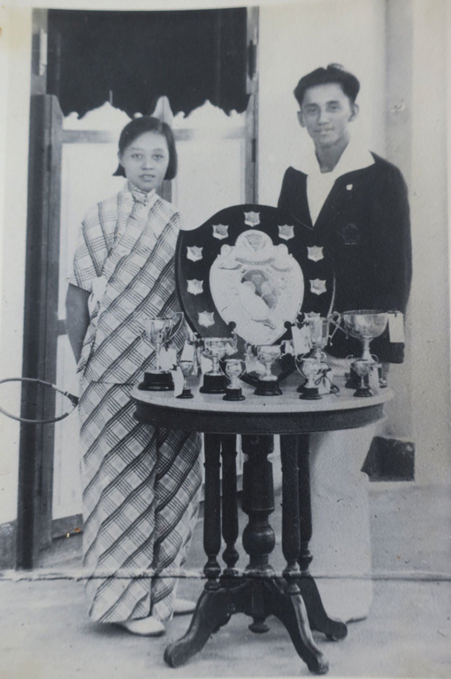 Grandma and grandfather, mixed doubles champions with some of their trophies at the front porch of No. 154 Jalan Ngee Heng. 