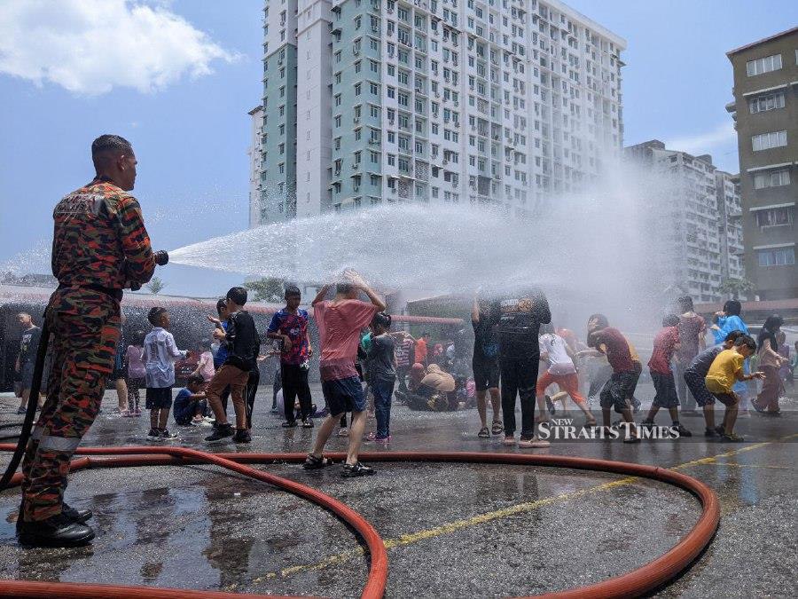 The shower, symbolic of the celebration of Malaysia Day, was one the activities carried out during ‘A Day with Bomba (Fire and Rescue) Penang 2.0’ with the community. - NSTP/ ZUHAINY ZULKIFFLI